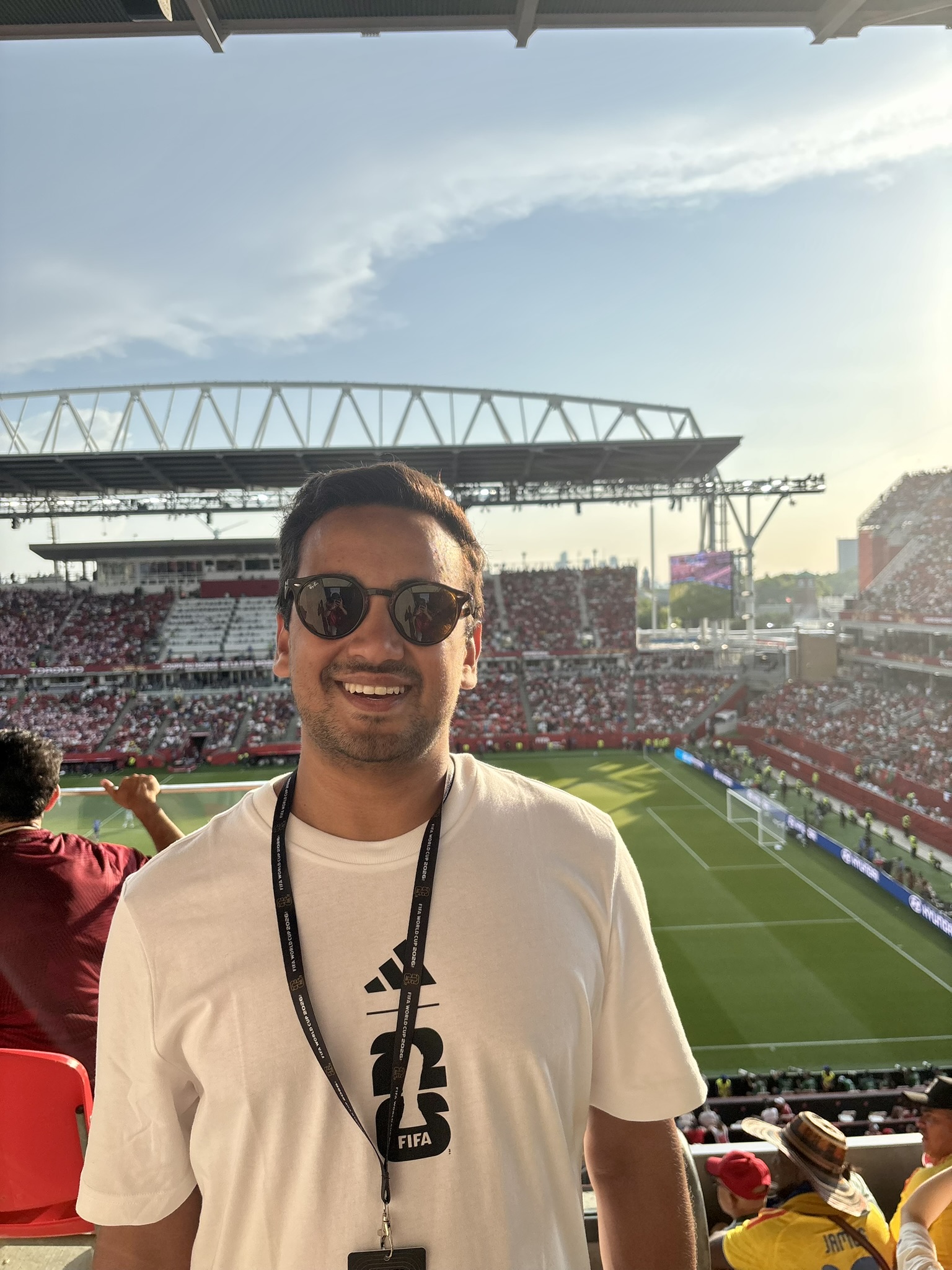 Nuwan smiling in the stands at a football match